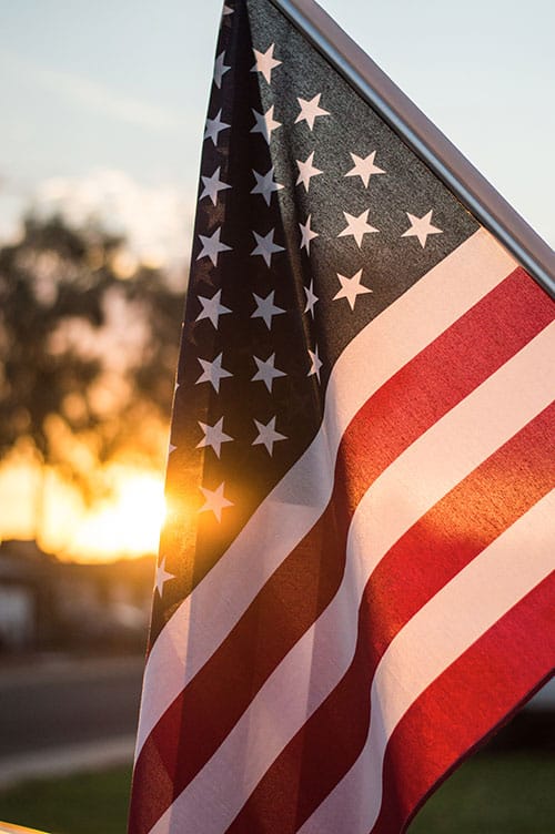 American flag with the sunset backlighting it