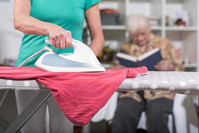 household Home helper ironing clothes for elderly woman