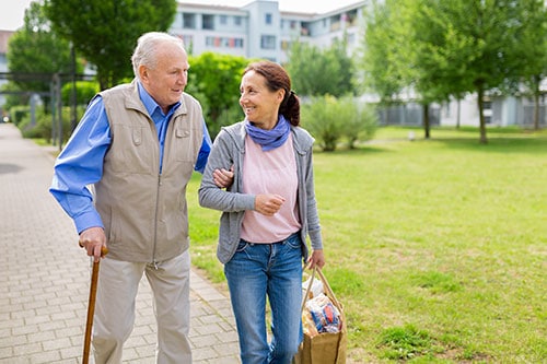 Caregiver woman helping senior man with shopping